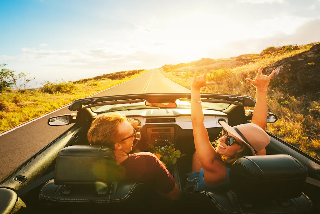 Happy couple driving in convertible
